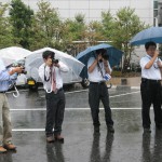 新聞社も傘をさして撮影