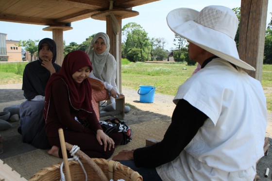 インドネシアから来たという女性達と「火起こし」体験。古代衣装のボランティアが教えてくれる。
